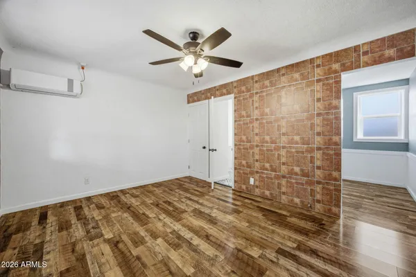 a view of room with a ceiling fan and wooden floor