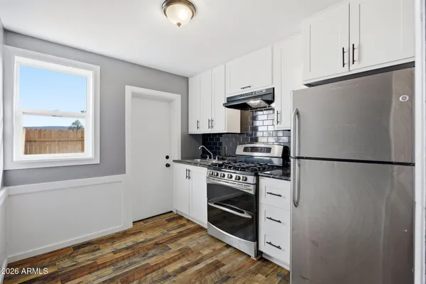 a kitchen with stainless steel appliances granite countertop a refrigerator sink and stove