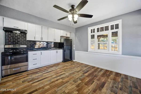 a kitchen with a stove cabinets and a window