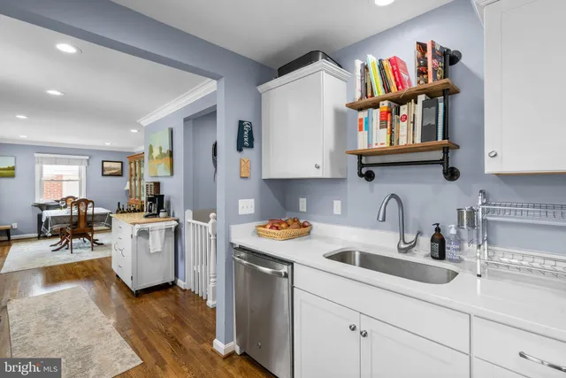 a kitchen with a sink dishwasher and a stove with wooden floor