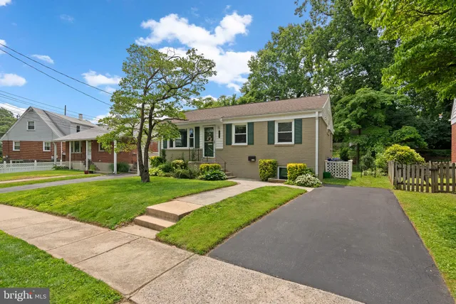 a front view of a house with a yard and tree