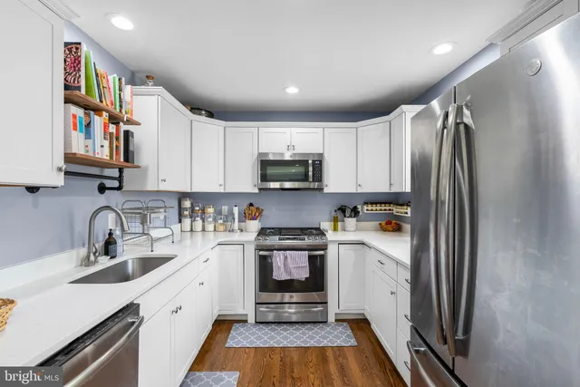a kitchen with stainless steel appliances a refrigerator sink and microwave