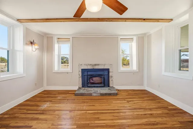 a view of a livingroom with wooden floor and a fireplace
