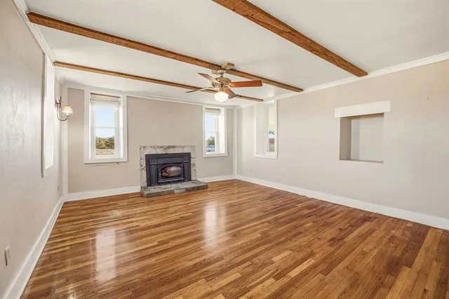 a view of empty room with wooden floor and fireplace
