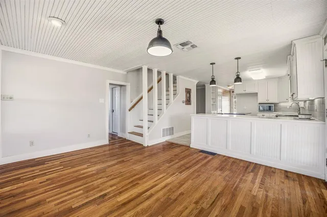 a view of a kitchen with wooden floor and a sink