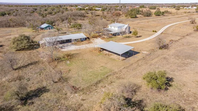 an aerial view of a house with a yard and ocean view