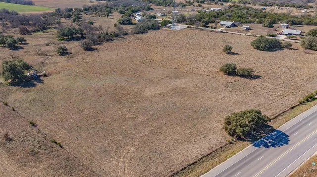 a view of a dry yard with wooden fence