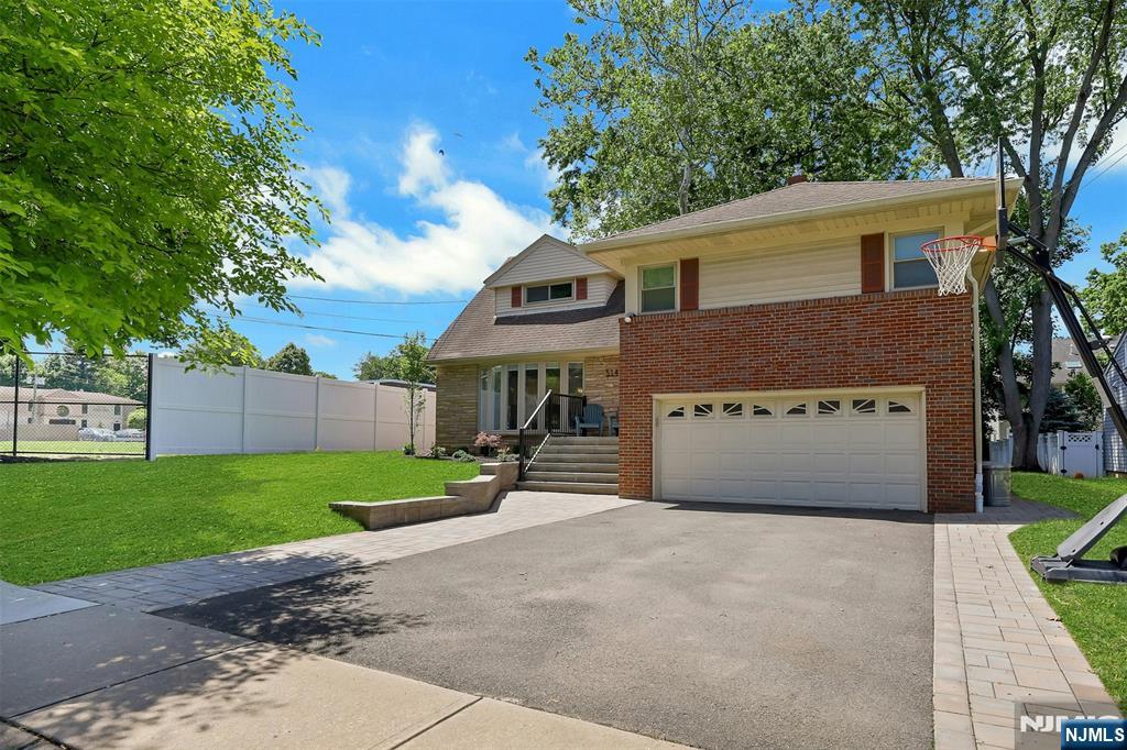 514 Rutland Avenue Teaneck, NJ 07666 - Photo 2 of 40 a front view of a house with a yard and garage