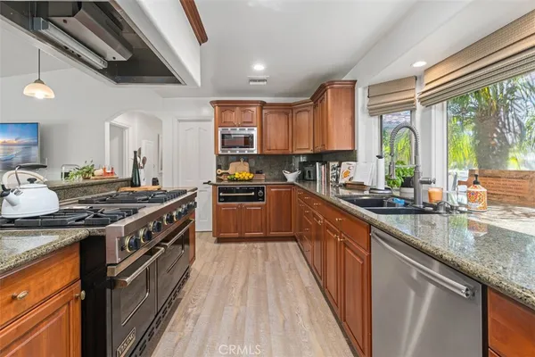 a kitchen with large windows a sink and a stove