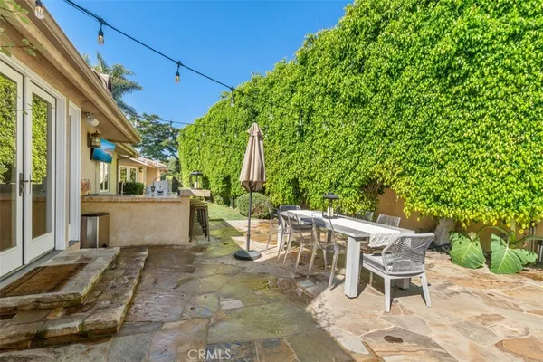 a view of a patio with table and chairs with wooden floor and fence
