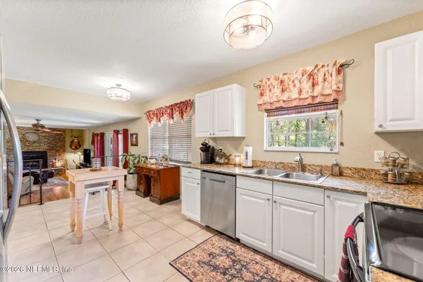 a room with stainless steel appliances kitchen island granite countertop a sink and cabinets