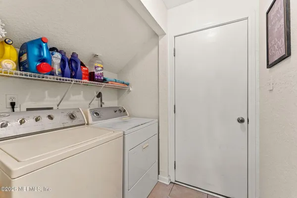 a view of a patio with table and chairs potted plants and large tree
