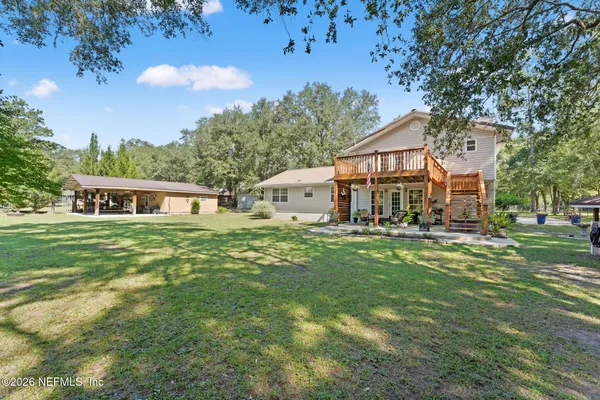 a view of a house with a yard and tree