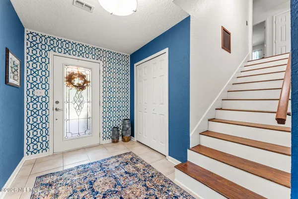 a bedroom with a bed and a large mirror on the dresser