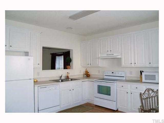 3360 Bridgeville Road Raleigh, NC 27610 - Photo 4 of 7 9' ceiling, hardwood floor, fluorescent light, bay window with mini blinds, stainless steel double sink with disposal, raised panel white cabinets, neutral countertop, dishwasher, smooth top stove, refrigerator, pantry, pass through to dining room Kitchen