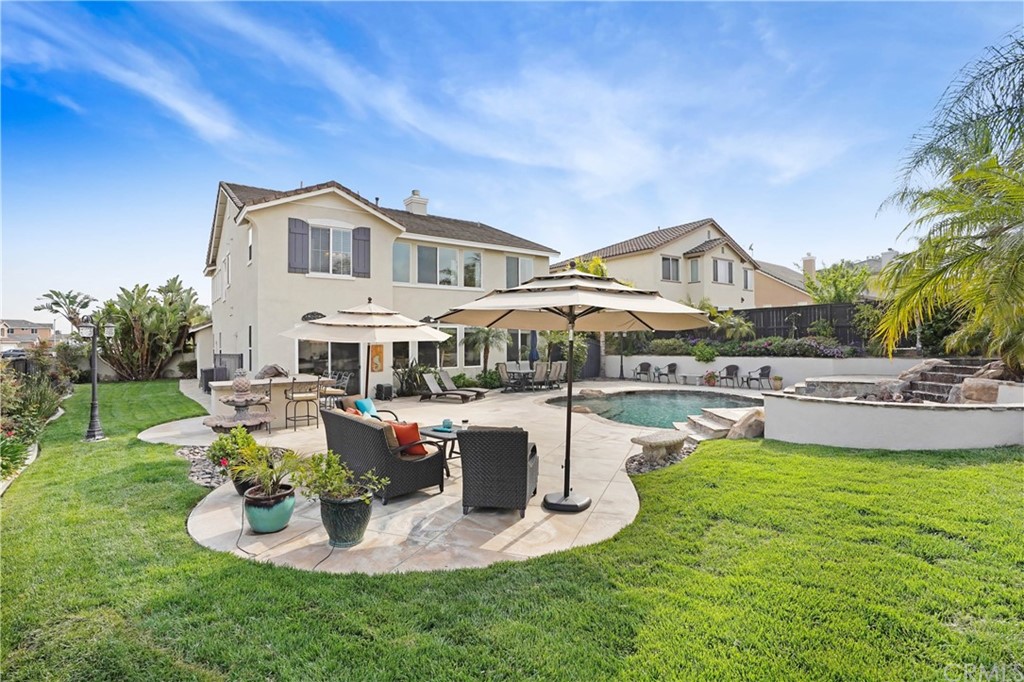 a front view of a house with swimming pool garden and patio