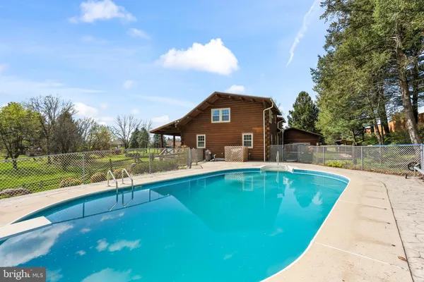 a view of a house with pool and yard
