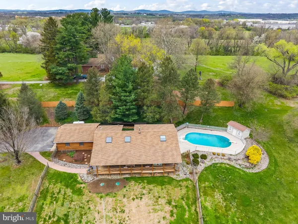 an aerial view of a house with a garden and swimming pool