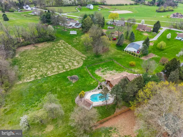 an aerial view of residential houses with outdoor space and trees