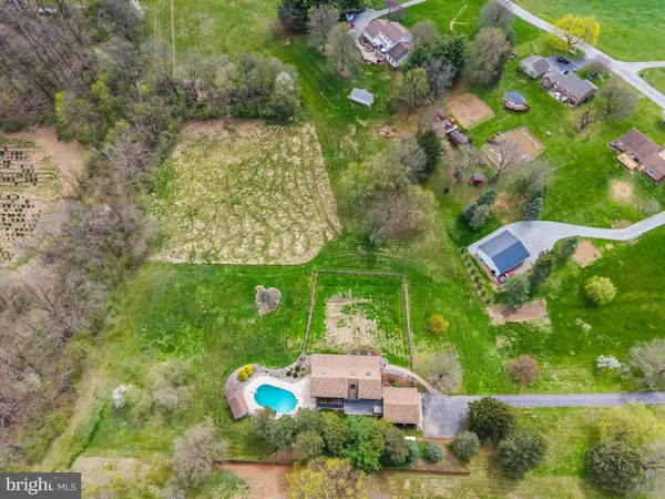a view of a big house with a big yard plants and large trees