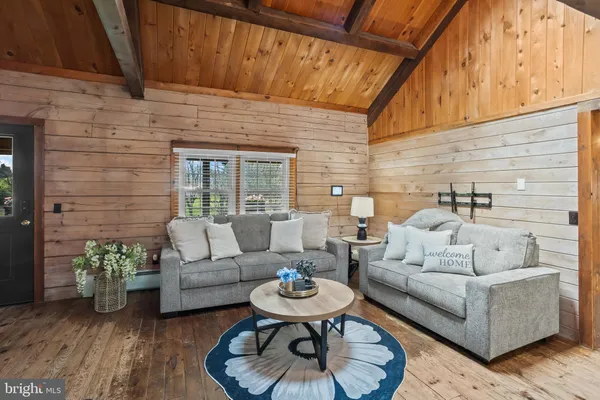a living room with furniture a wooden floor and a rug