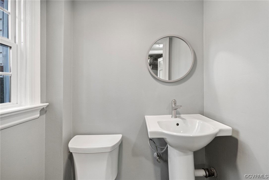 10240 Apache Road Richmond, VA 23235 - Photo 12 of 45 a bathroom with a toilet sink and mirror