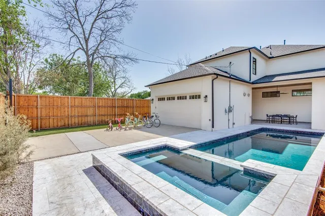 a view of a white house with a large pool and wooden fence