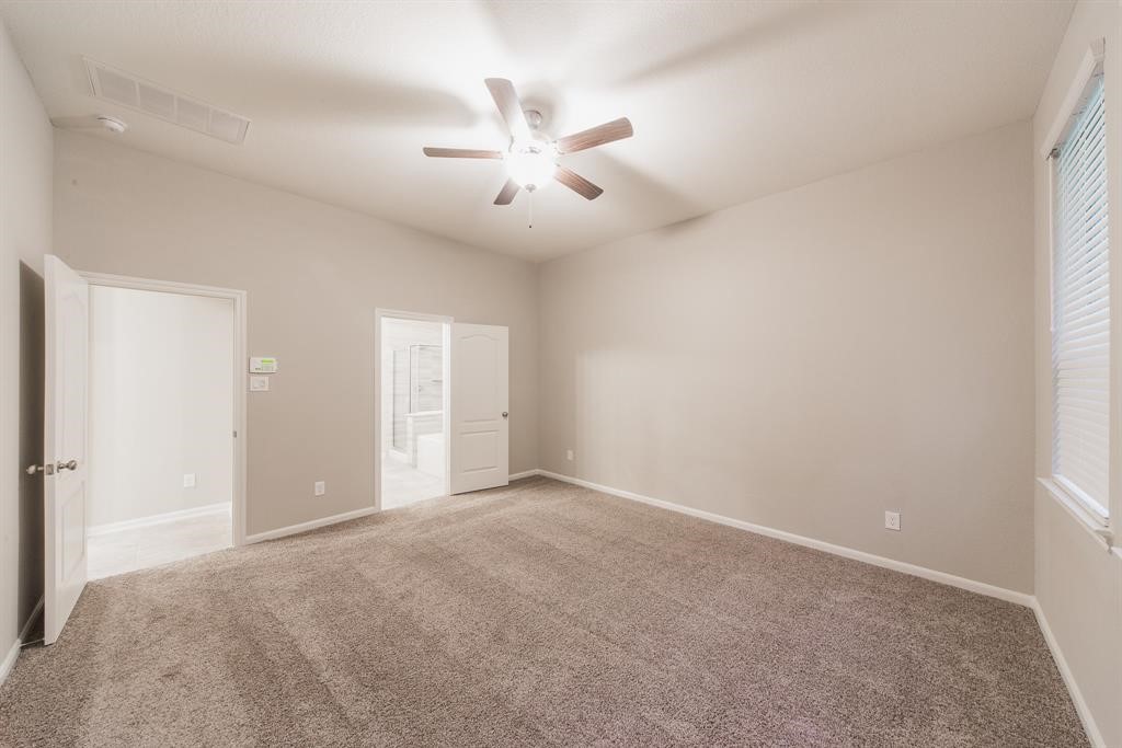 3219 Montclair Orchard Trace Spring, TX 77386 - Photo 14 of 27 a view of an empty room with a ceiling fan and a window