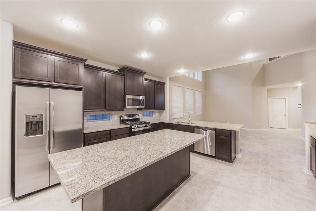 3219 Montclair Orchard Trace Spring, TX 77386 - Photo 10 of 27 a kitchen with stainless steel appliances granite countertop a sink refrigerator and cabinets