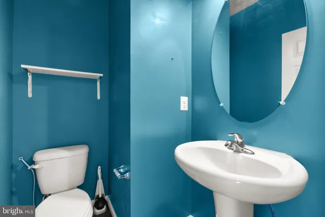 a bathroom with a toilet sink and mirror