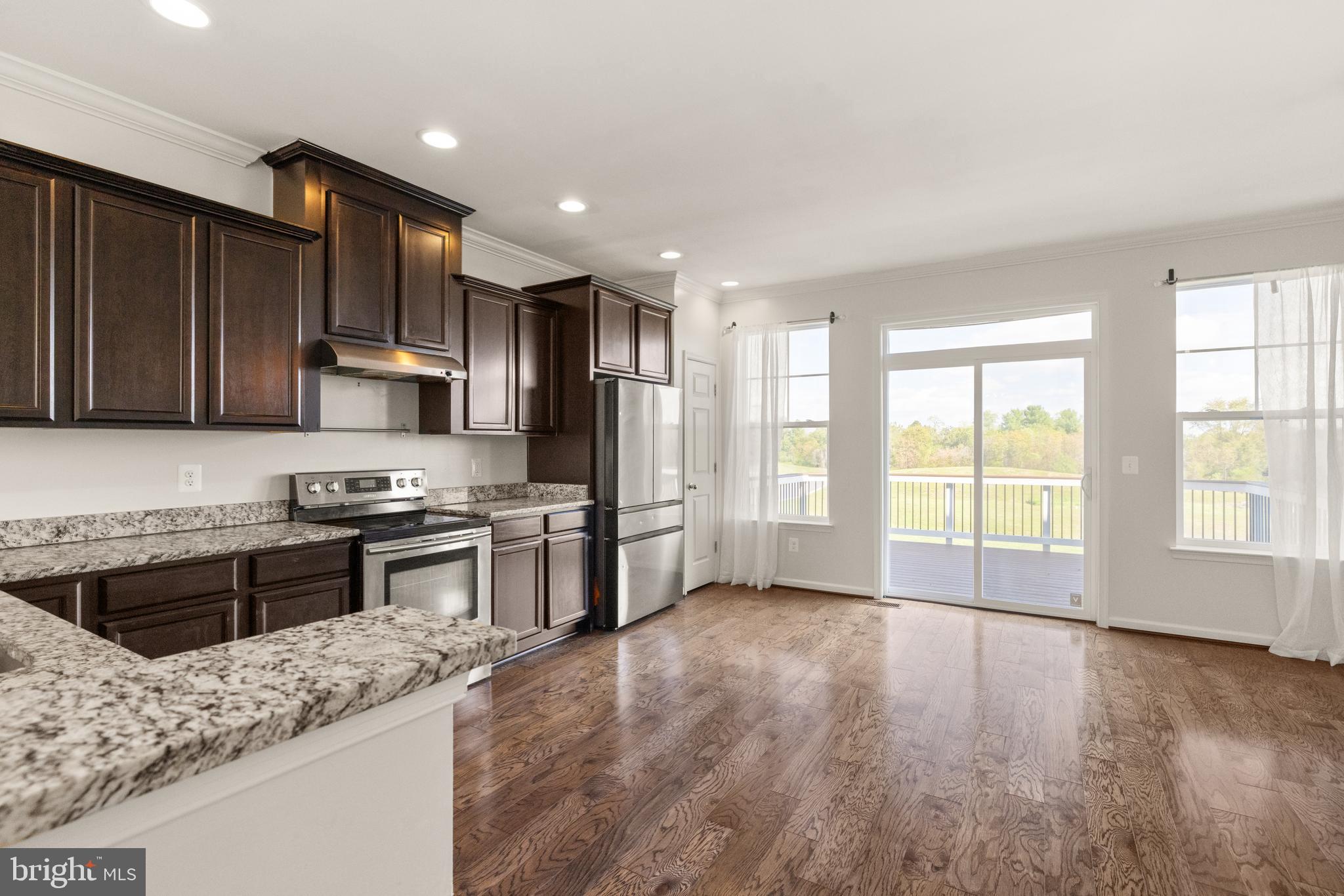 111 Rotunda Drive Stephenson, VA 22656 - Photo 5 of 33 a kitchen with stainless steel appliances granite countertop a stove a sink a refrigerator white cabinets and wooden floor