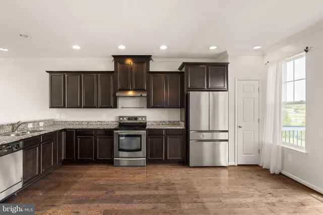 a kitchen with granite countertop stainless steel appliances a refrigerator and a sink