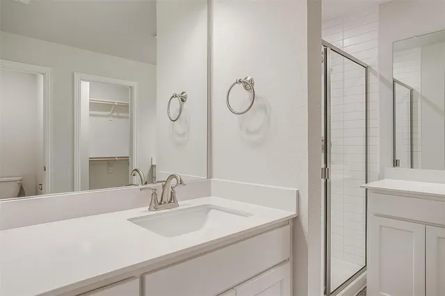 a bathroom with a double vanity sink mirror and shower