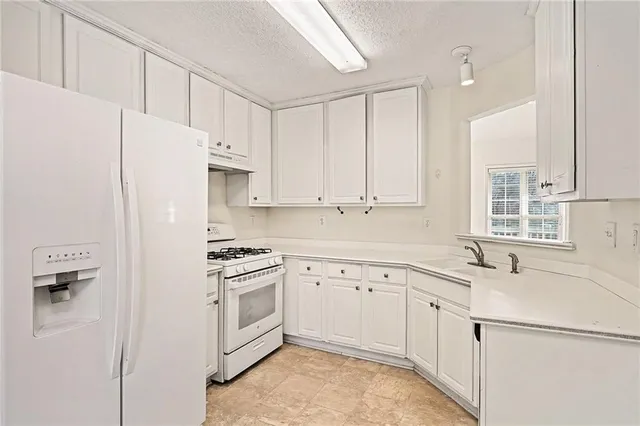 a kitchen with white cabinets and white appliances