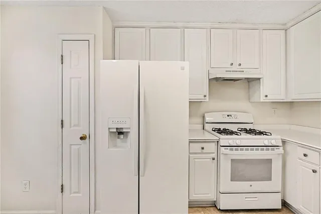 a kitchen with white cabinets and white appliances
