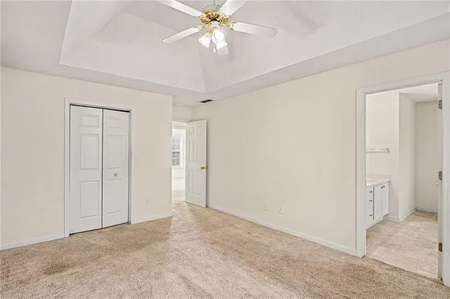 a view of an empty room and chandelier fan