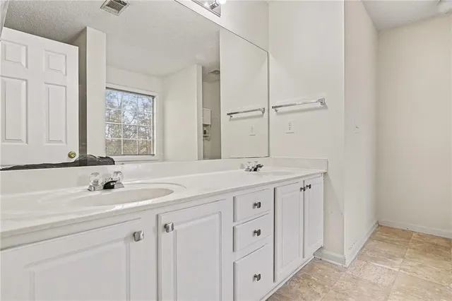 a bathroom with double sink and a mirror
