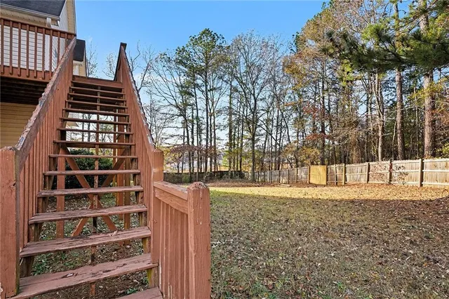 a view of a yard with wooden fence