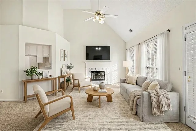 a living room with furniture a fireplace and a flat screen tv