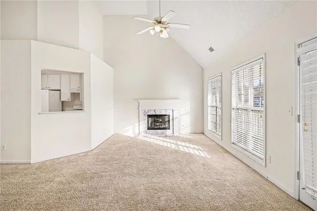 an empty room with windows and fireplace