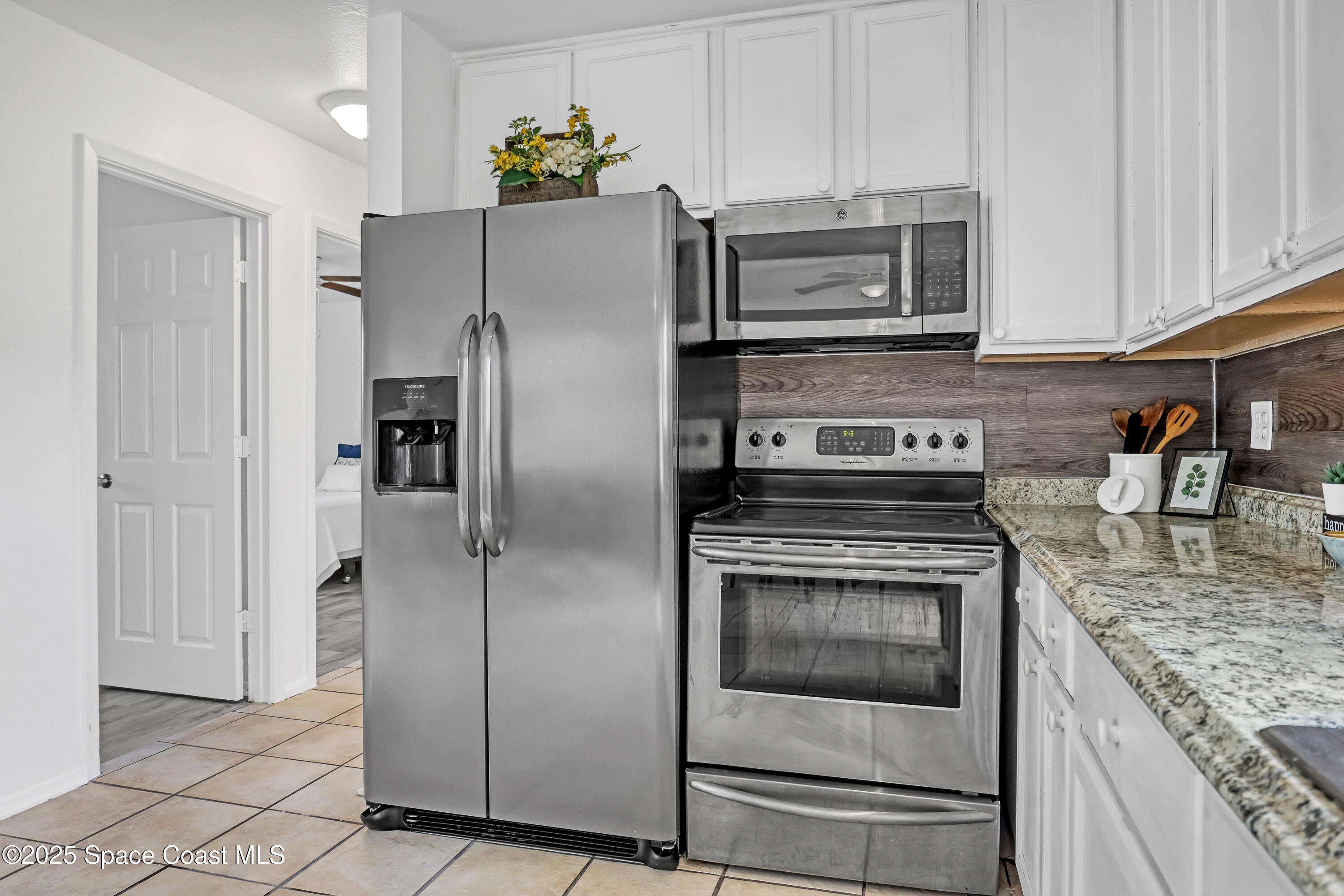 261 Chase Road Cocoa, FL 32927 - Photo 11 of 26 a kitchen with granite countertop a refrigerator stove and microwave