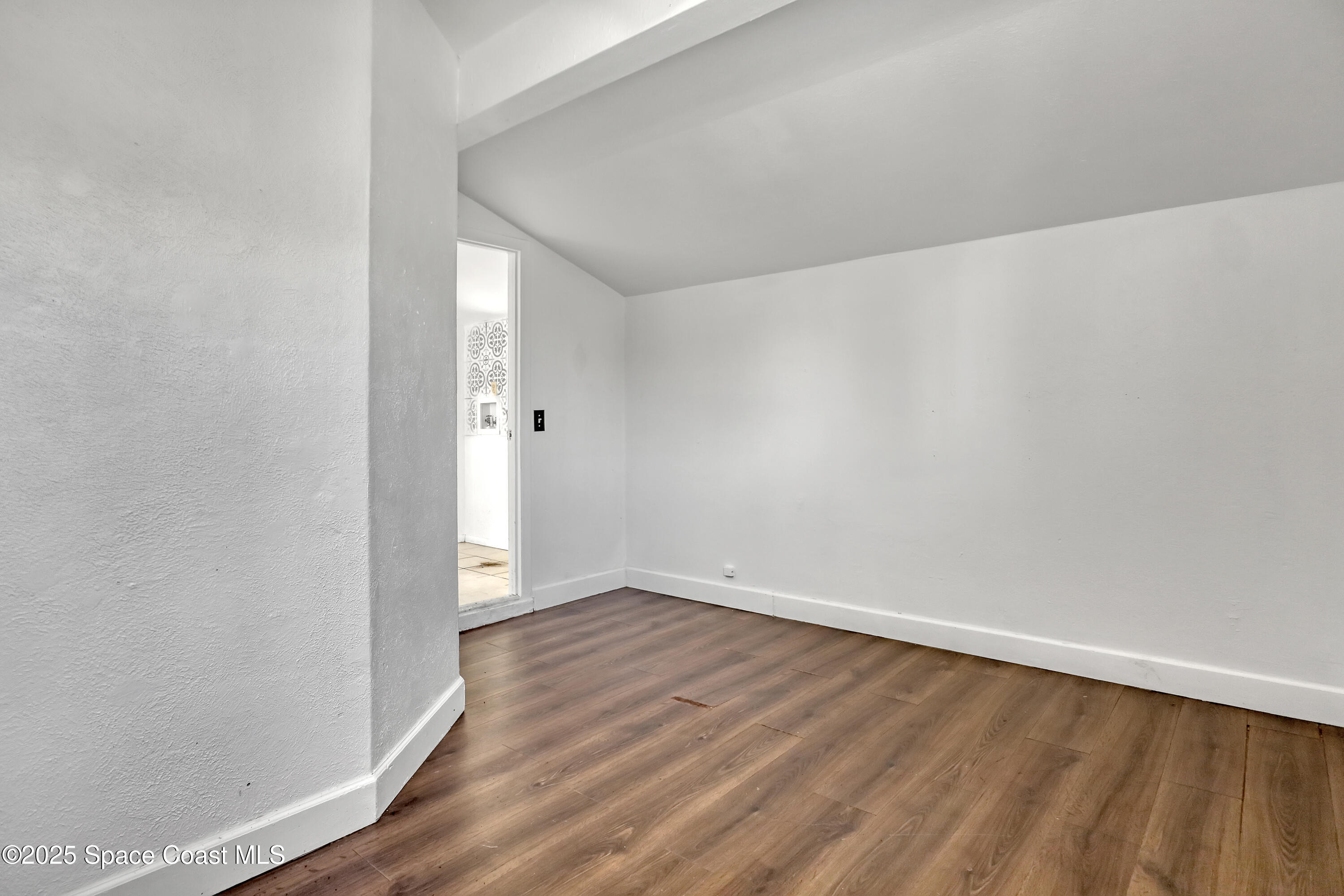 261 Chase Road Cocoa, FL 32927 - Photo 16 of 26 a view of an empty room with wooden floor
