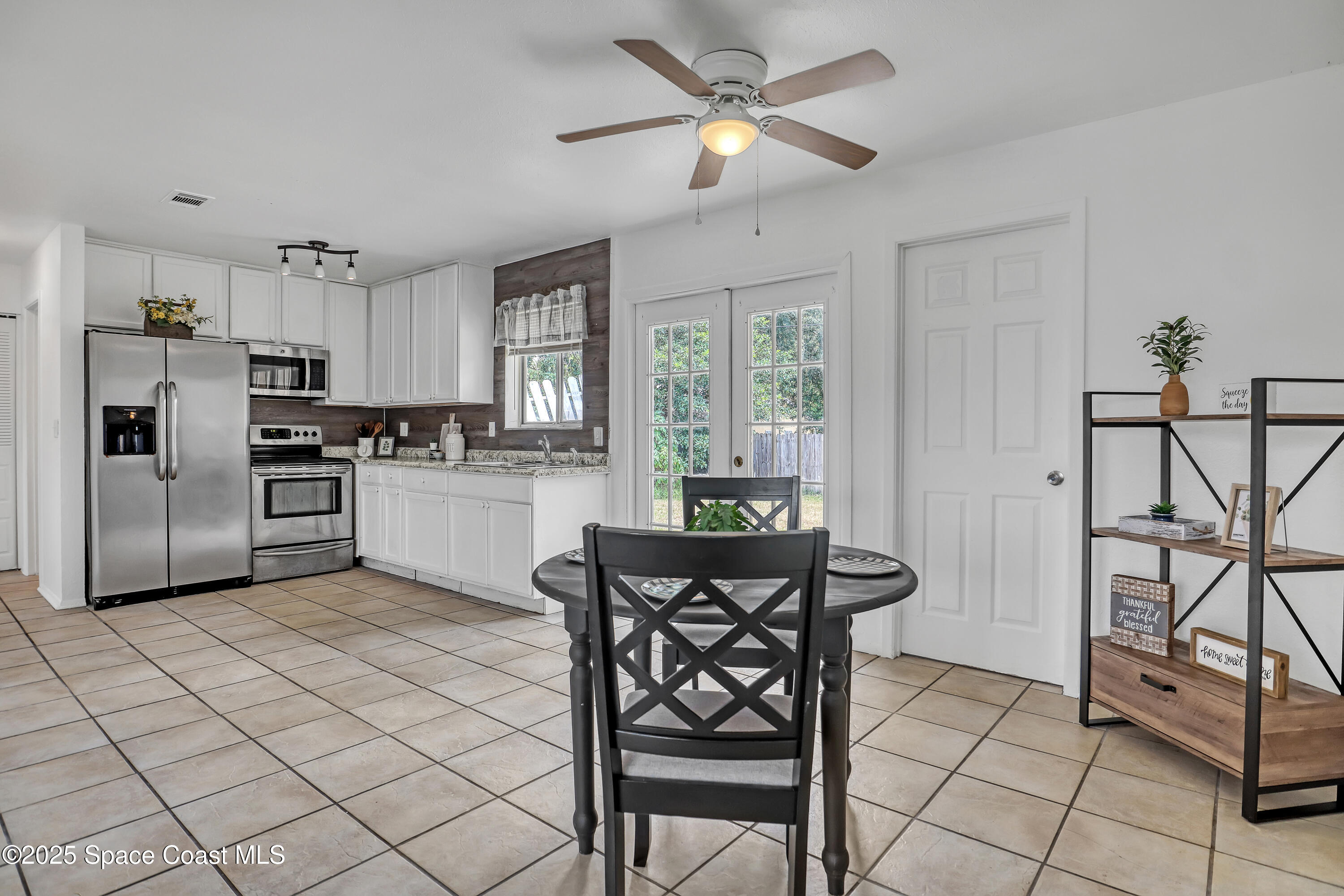 261 Chase Road Cocoa, FL 32927 - Photo 7 of 26 a kitchen with stainless steel appliances granite countertop a stove a refrigerator and a dining table chair