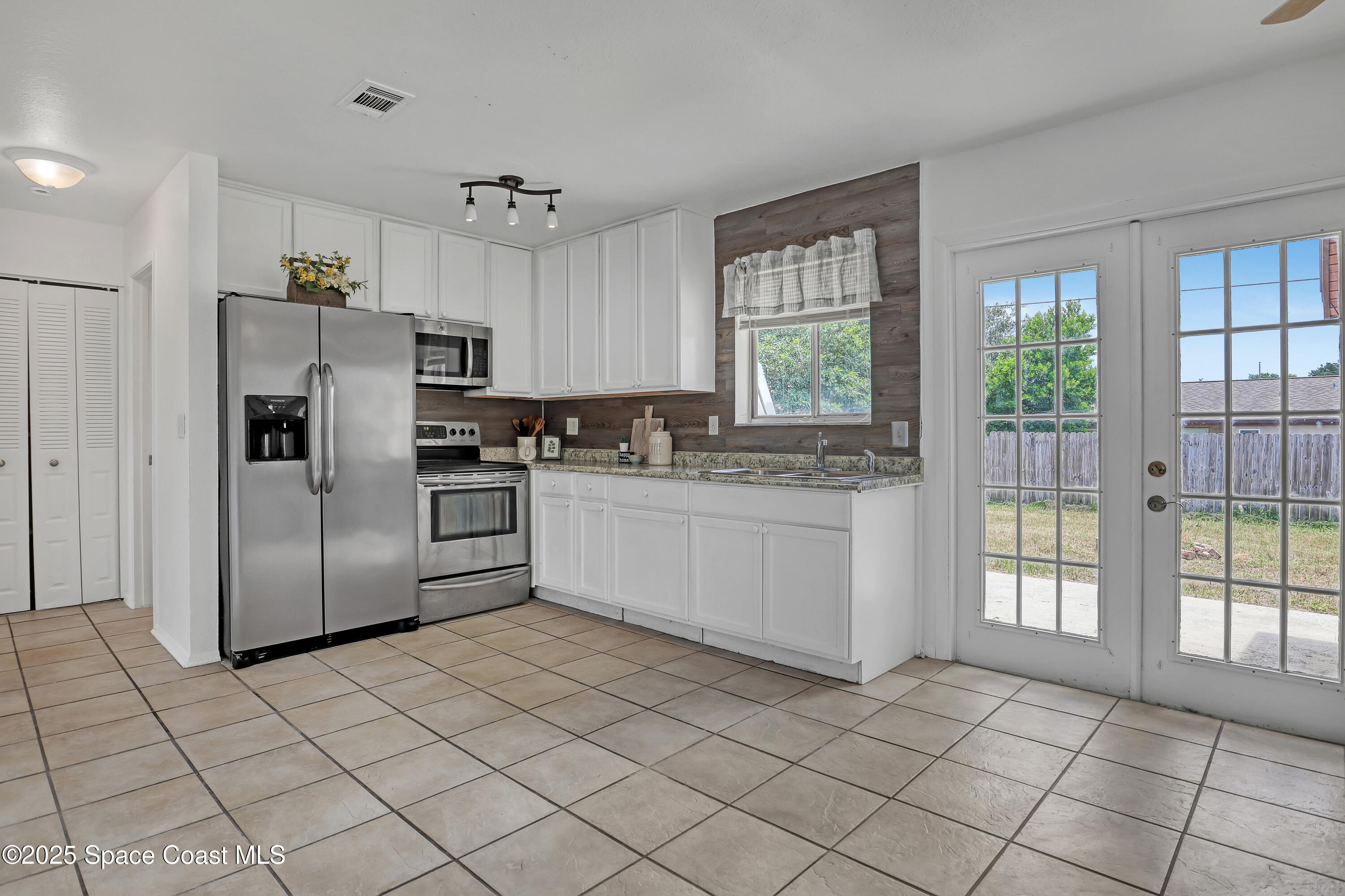 261 Chase Road Cocoa, FL 32927 - Photo 8 of 26 a kitchen with stainless steel appliances a refrigerator sink and cabinets