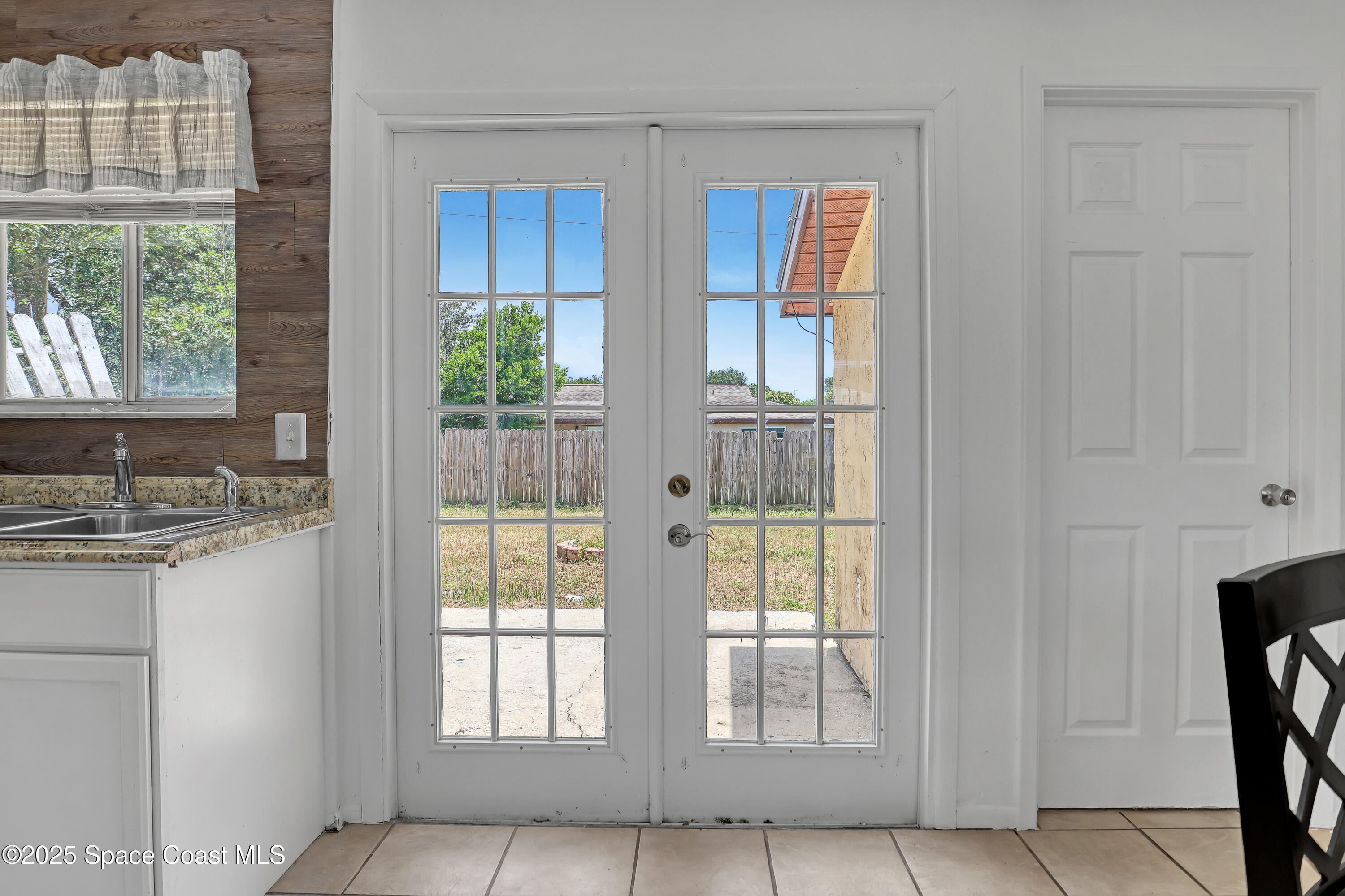 261 Chase Road Cocoa, FL 32927 - Photo 9 of 26 a view of an empty room with wooden floor and windows