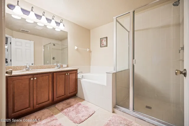 a spacious bathroom with a mirror a sink and a shower