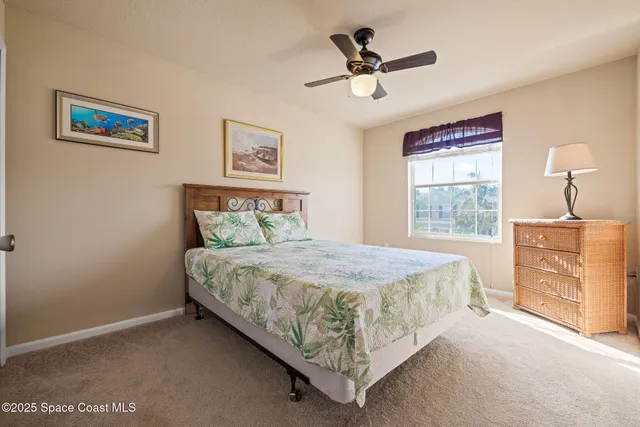 a bedroom with a bed a dresser and window