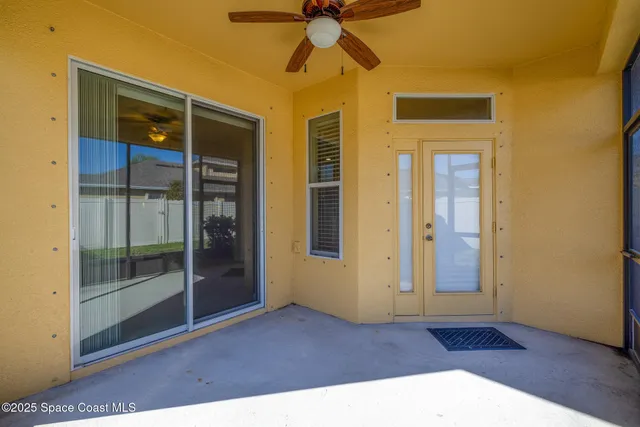 a view of a hallway with wooden floor and a ceiling fan