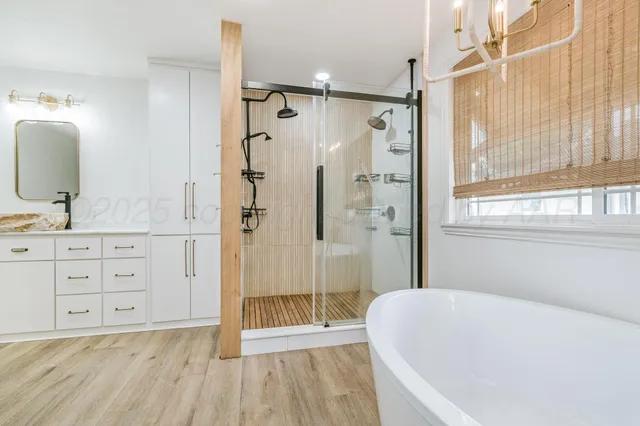 a bathroom with a tub a sink and shower