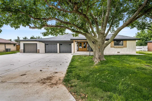 a white house that has a tree in front of it